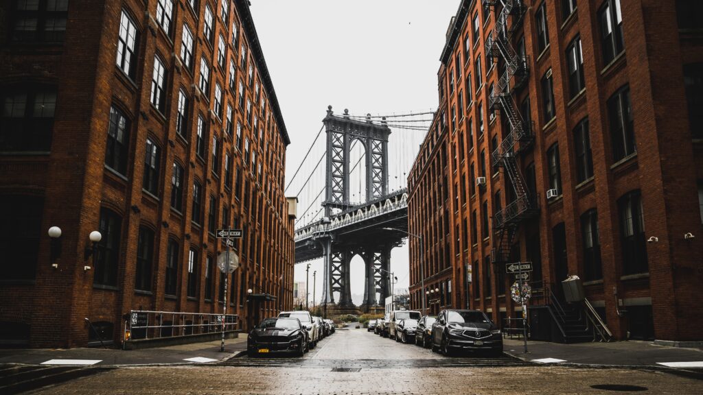 A street in new york city with a manhattan bridge in the background.
