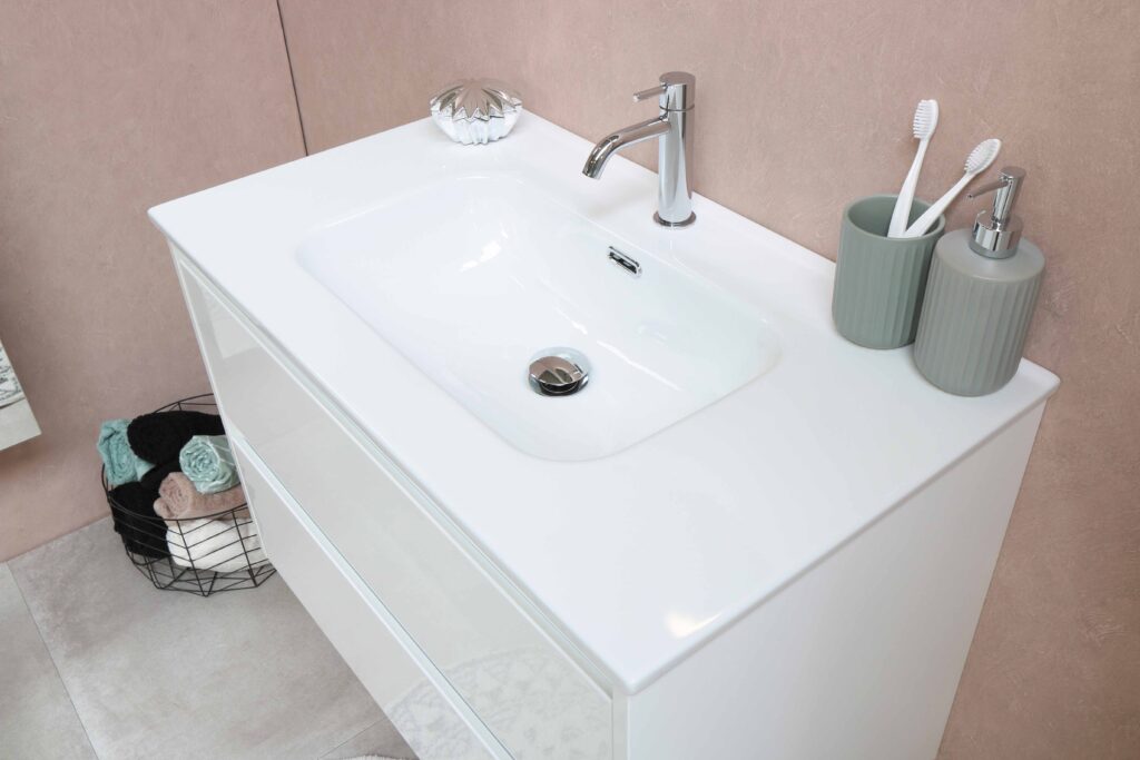 A bathroom with a white sink and toothbrushes.
