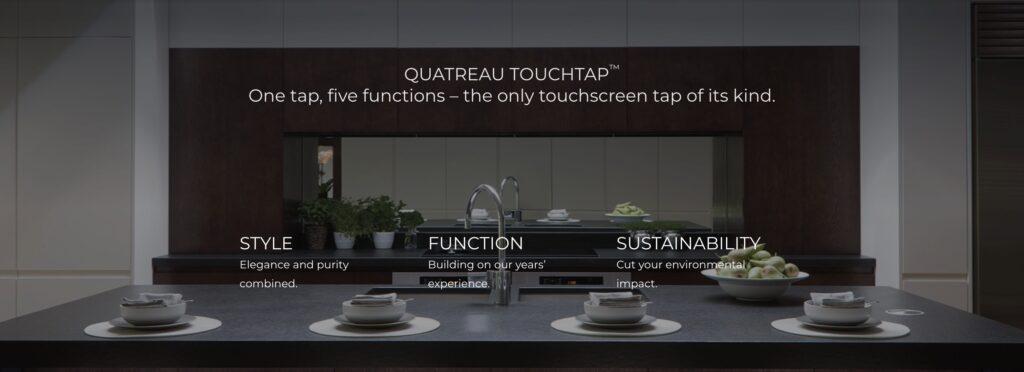 A kitchen counter with a QUATREAU TOUCHTAP™, a cup of coffee, and a cup of tea.