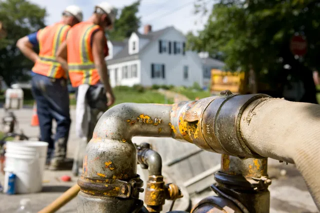 A group of construction workers are busy piping a sprinkle pipes.