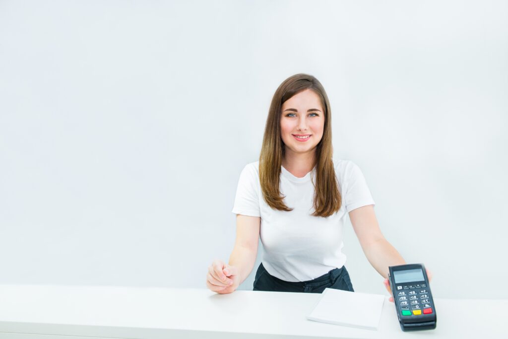 manager, seller holding payment terminal at reception desk. Contactless payment with nfc technology