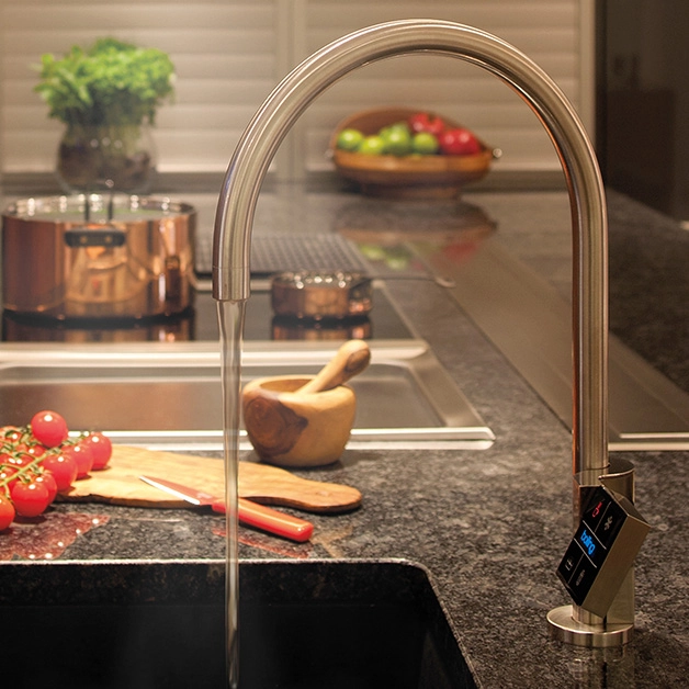 A kitchen sink with a faucet and vegetables on it.