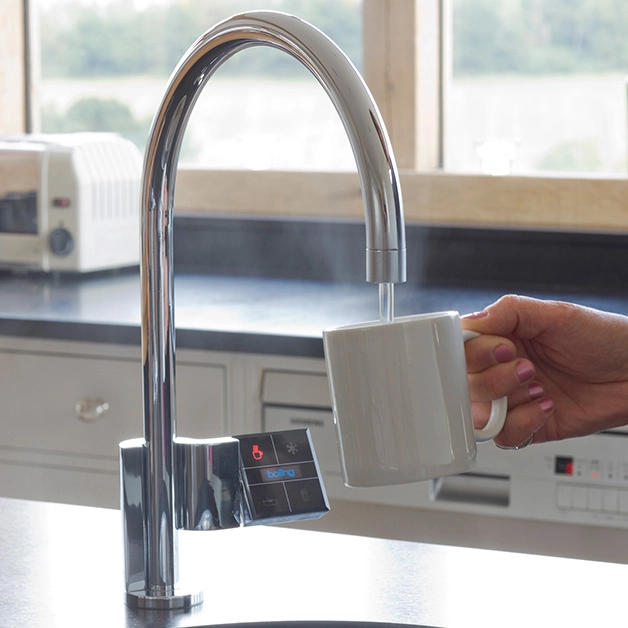 A person pouring a cup of coffee from a faucet.