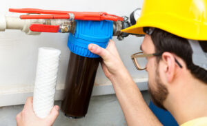 person installing a water filtration system