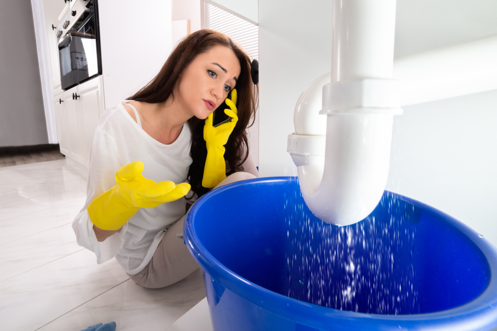 pipe dripping water into blue bucket