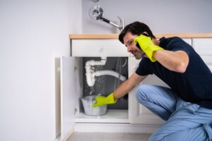 person calling a professional to help with their leaking pipe