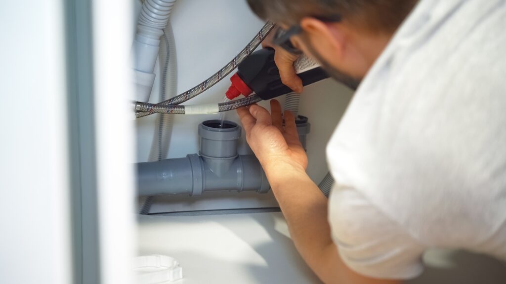 person using liquid to unclog a pipe